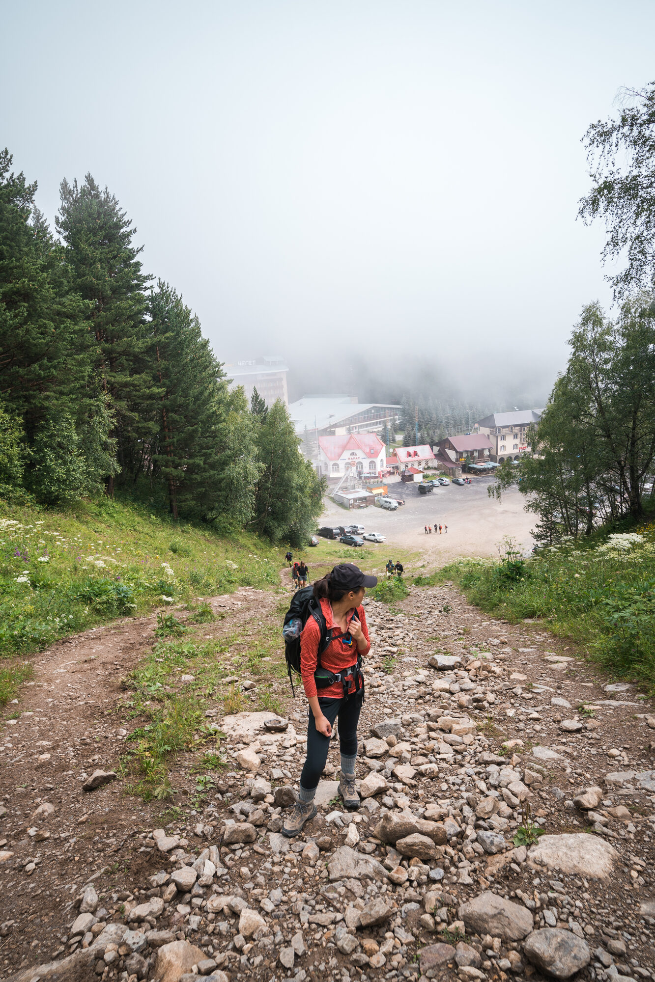 Climbers starting the acclimatization hike up Mount Cheget on a rocky trail above Terskol