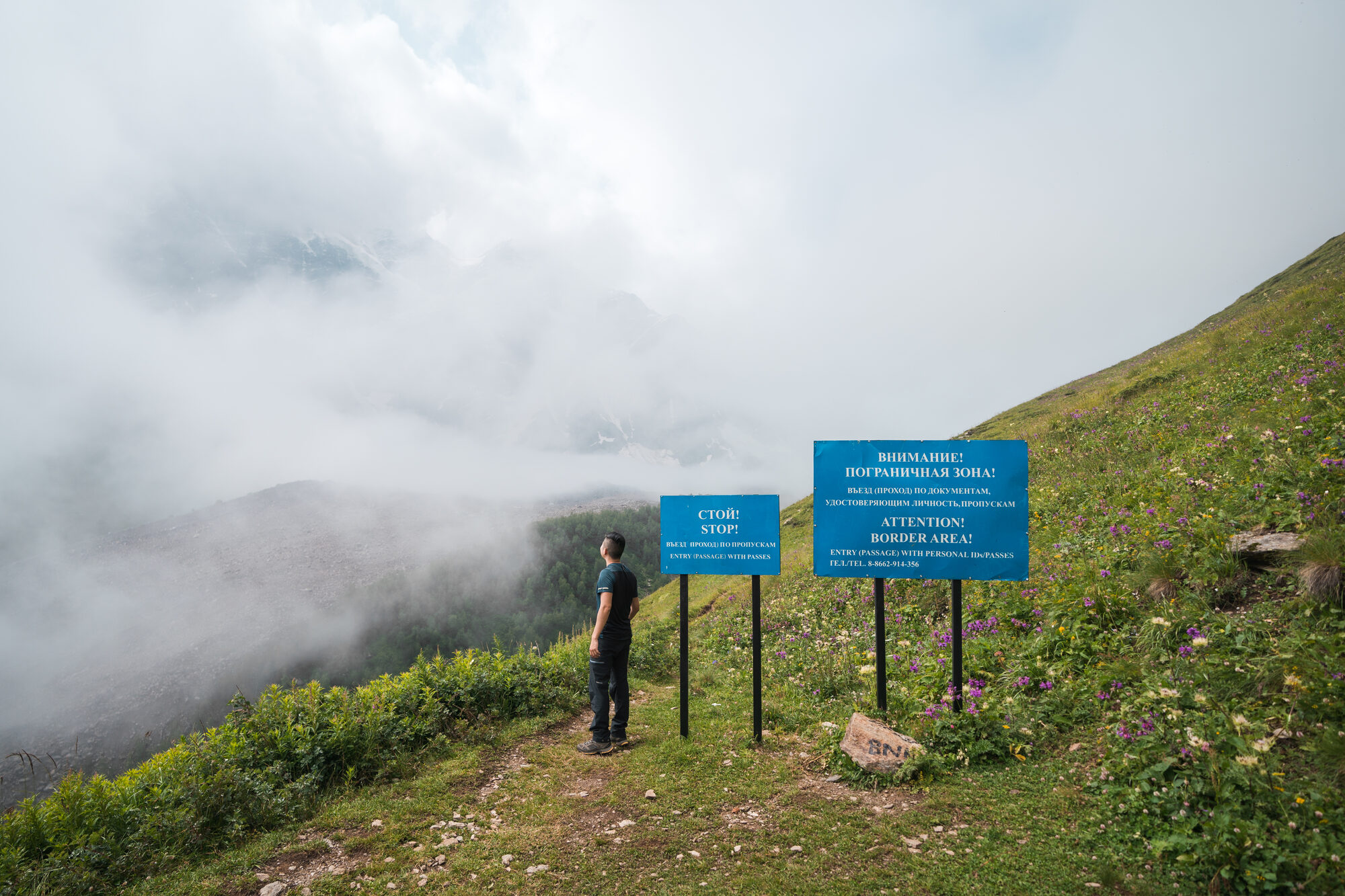 Climbers near a sign marking the border between Russia and Georgia high on Cheget