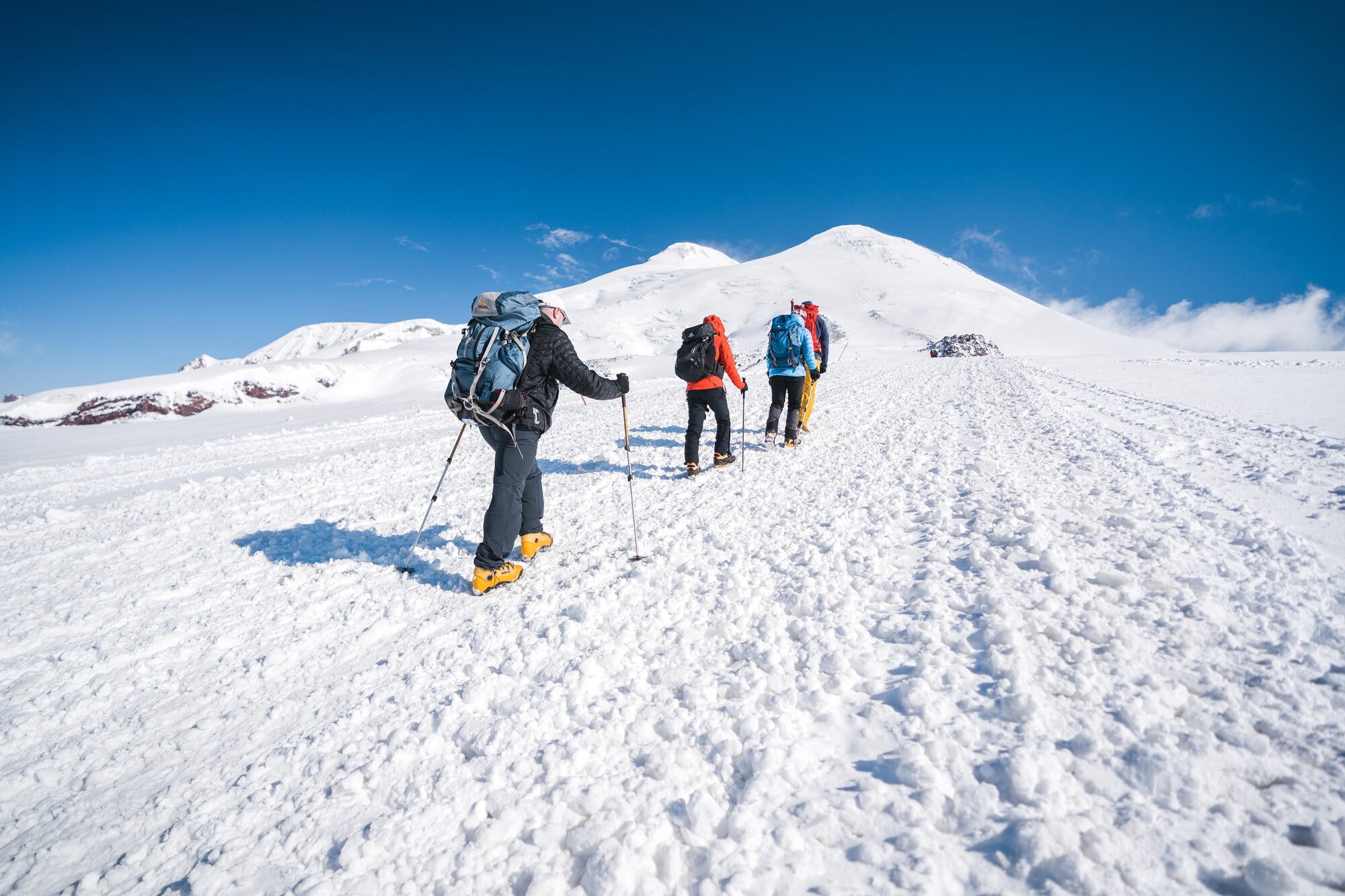 Climbers crossing the snow field toward Elbrus's twin summits