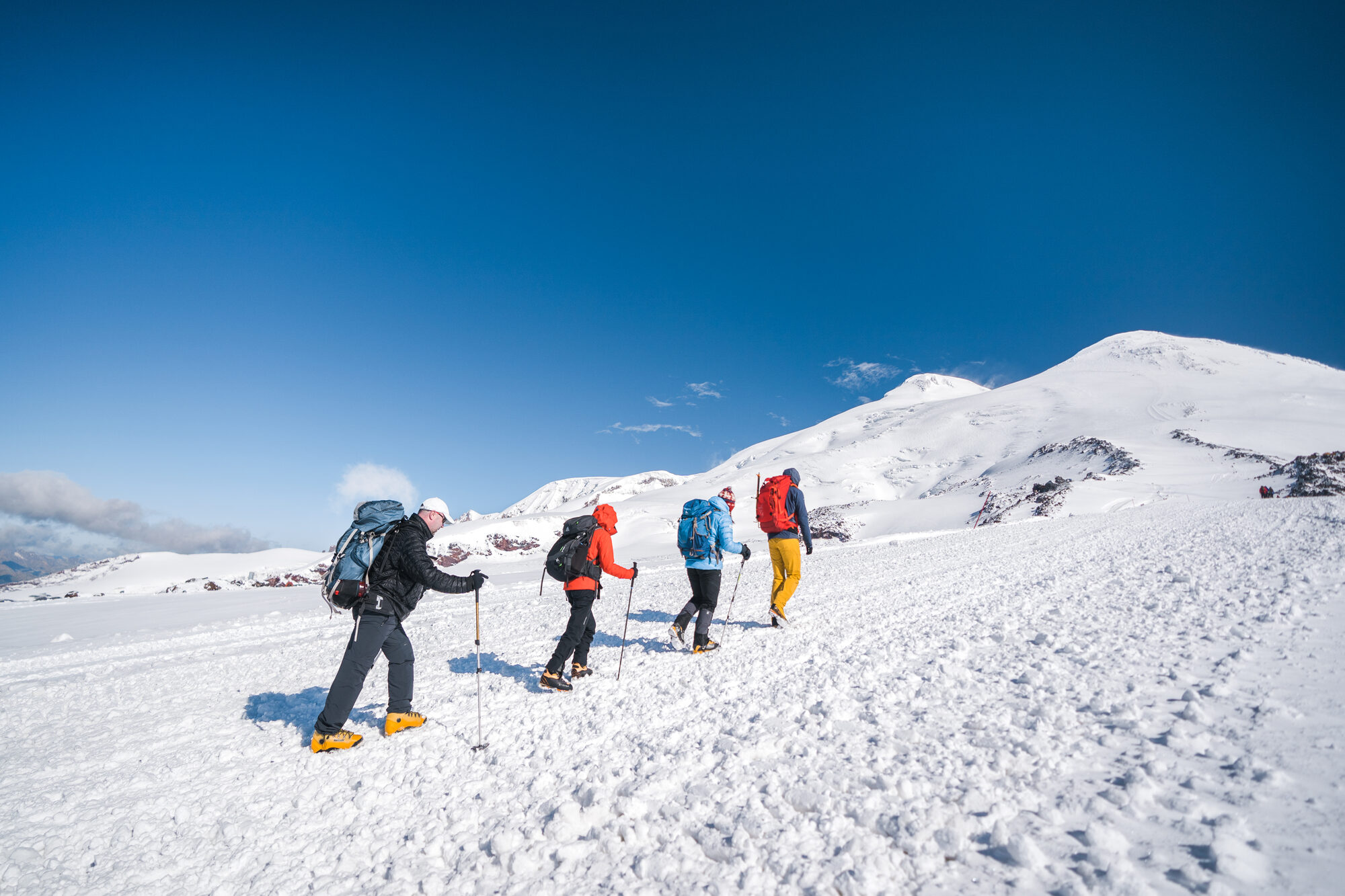 The team ascending Elbrus's upper snow slopes in clear weather