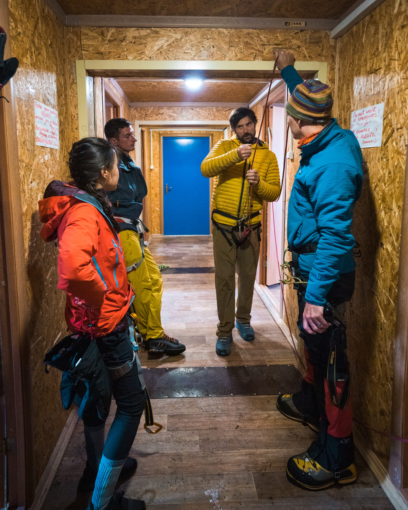 Mountain guide teaching rope and crampon skills inside the base camp hut