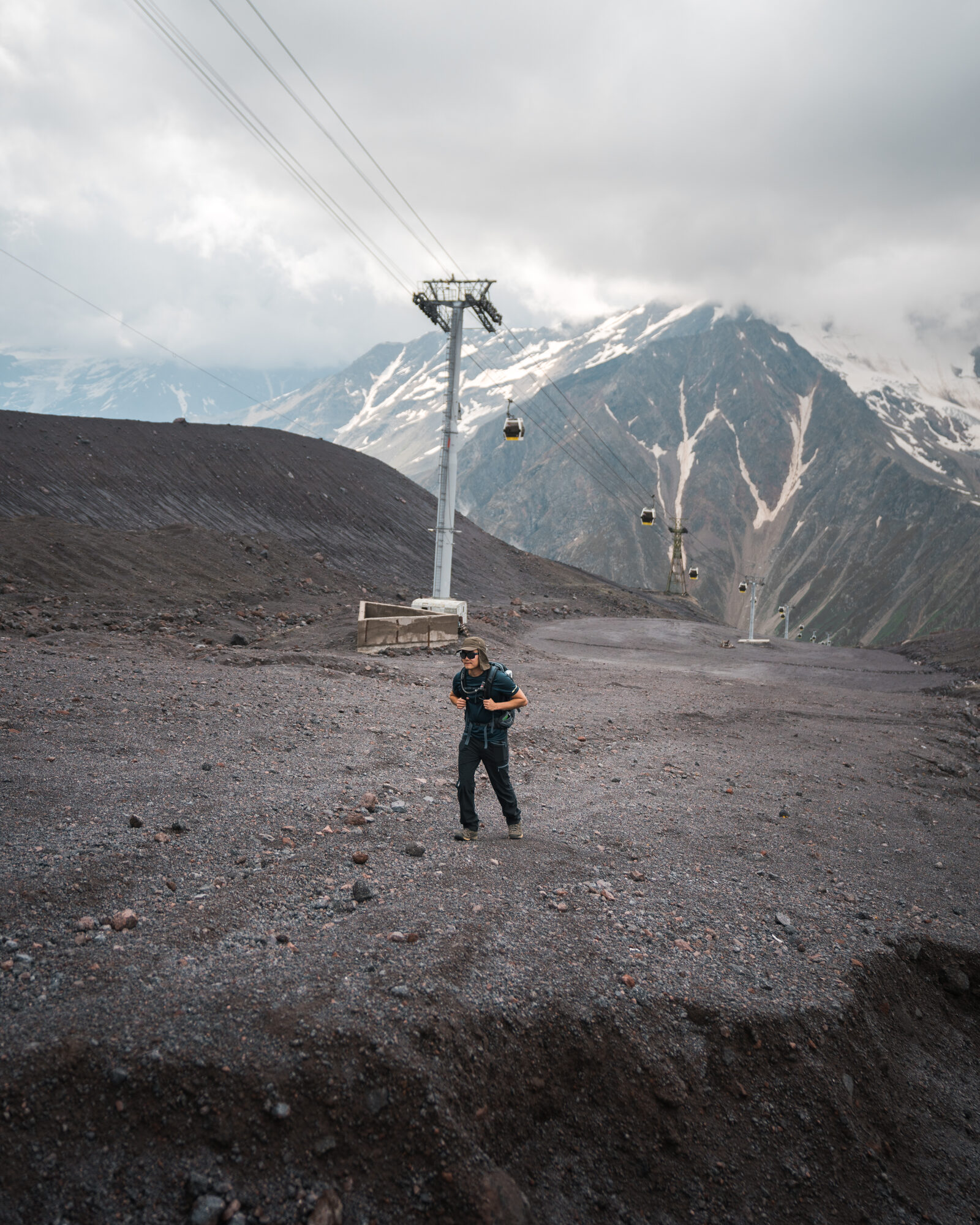 Jason standing near the cable car station with Elbrus peaks in the background