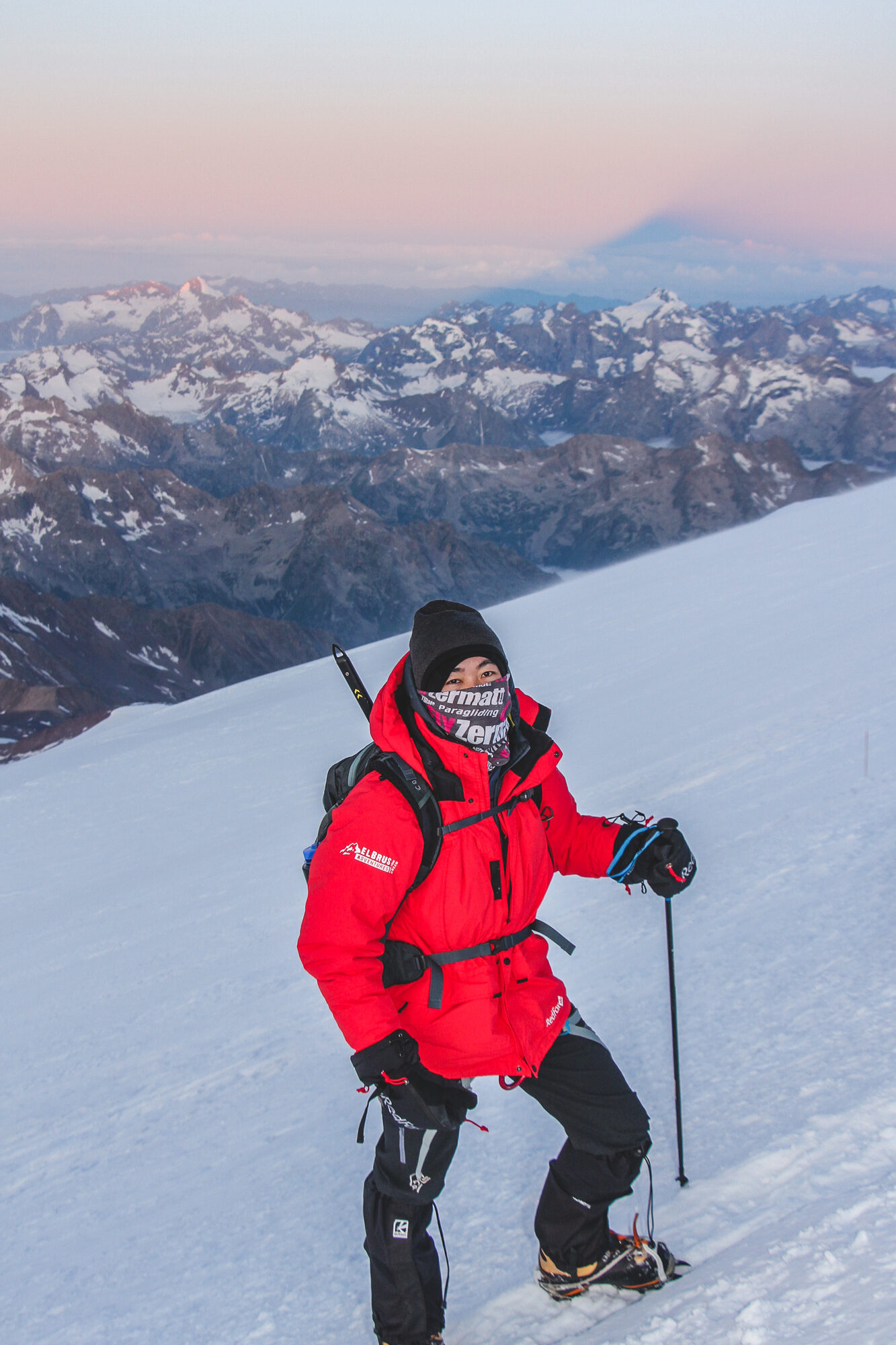 Jason climbing Elbrus at sunrise with Elbrus shadow visible on horizon