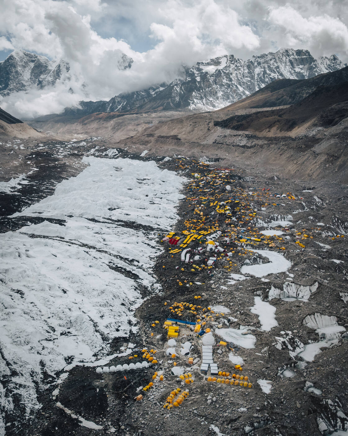 Aerial view of the Base Camp tents strung along the Khumbu Glacier beneath cloud-wrapped peaks