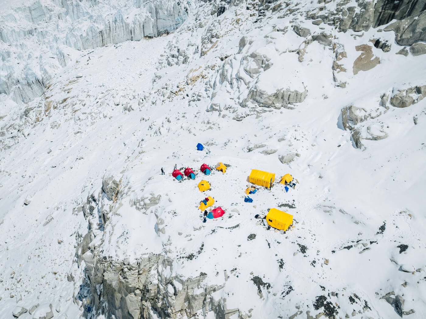Aerial view of a small cluster of tents on snow among ice blocks