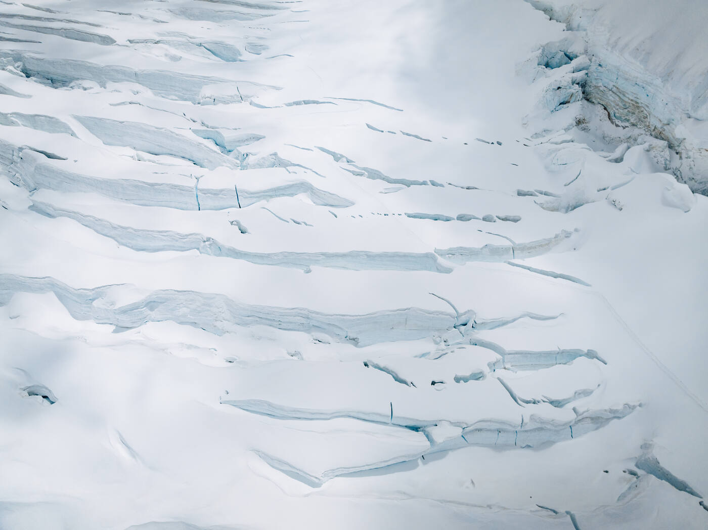 Aerial view of a line of climbers crossing a crevasse field