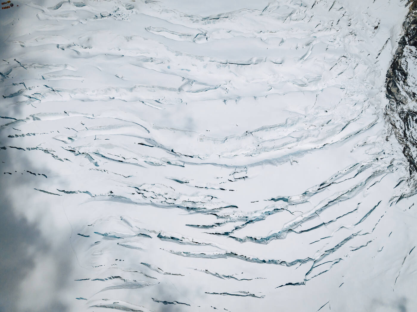 Aerial view of a field of parallel crevasses in the glacier