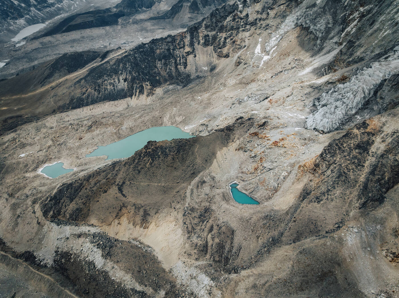 Aerial view of turquoise glacial lakes among the rocky moraine