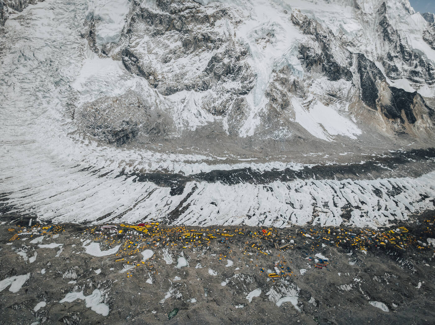 Aerial view of the Khumbu Icefall spilling down to the strip of Base Camp tents along the glacier