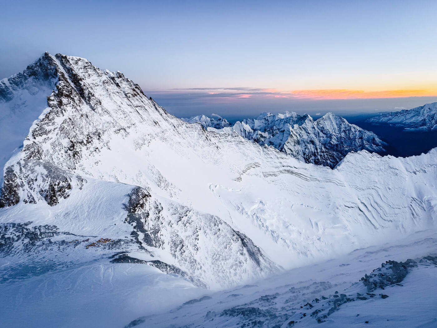 Aerial drone shot of Everest summit pyramid at sunset with golden light on the snow