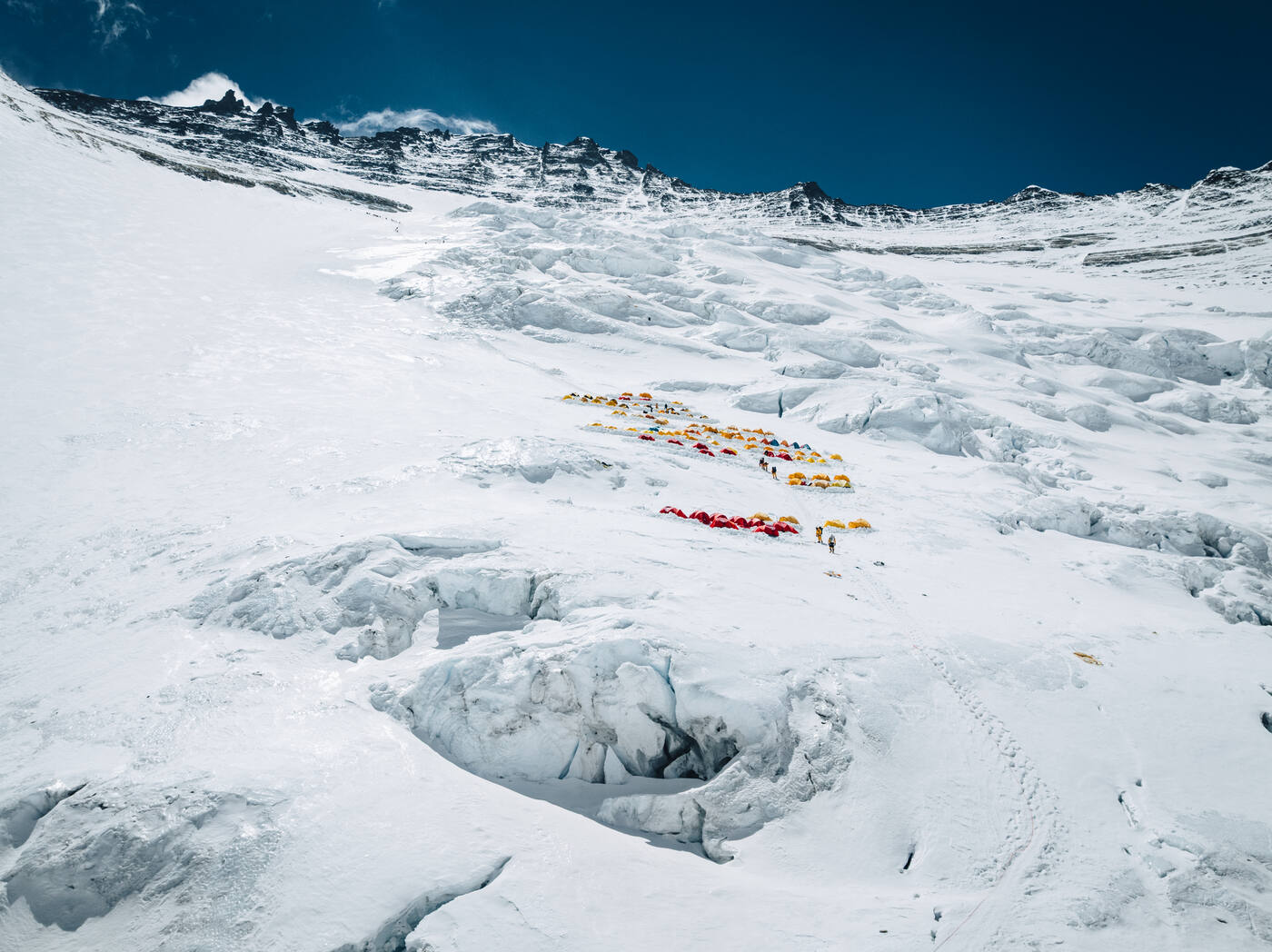 Aerial view of tents on the crevassed Lhotse Face with a rocky ridge above