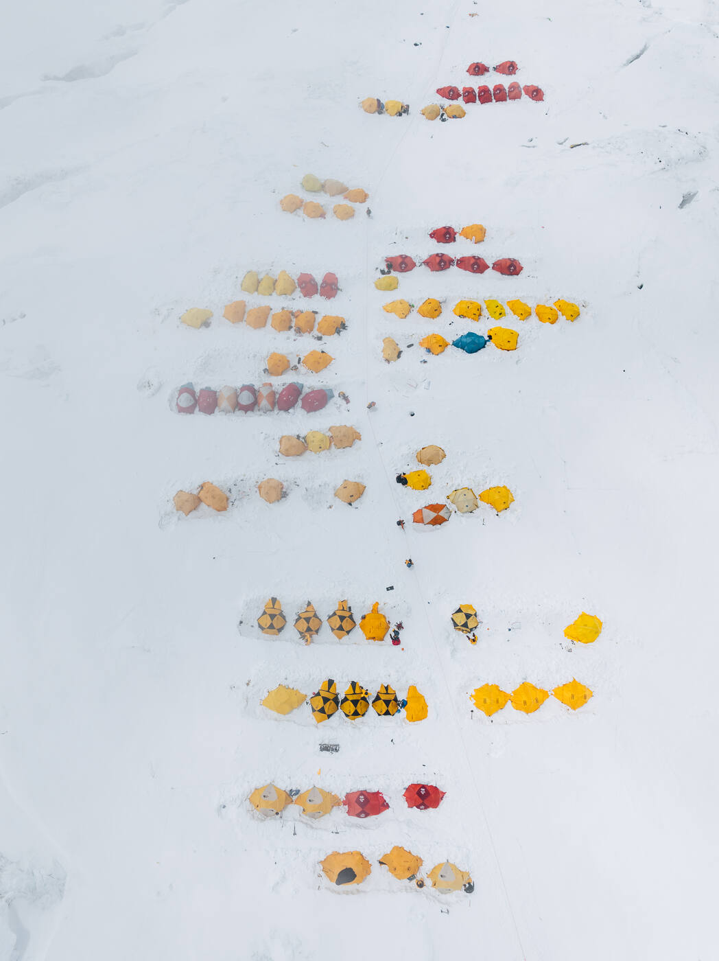 Aerial view straight down on rows of colorful tents on snow