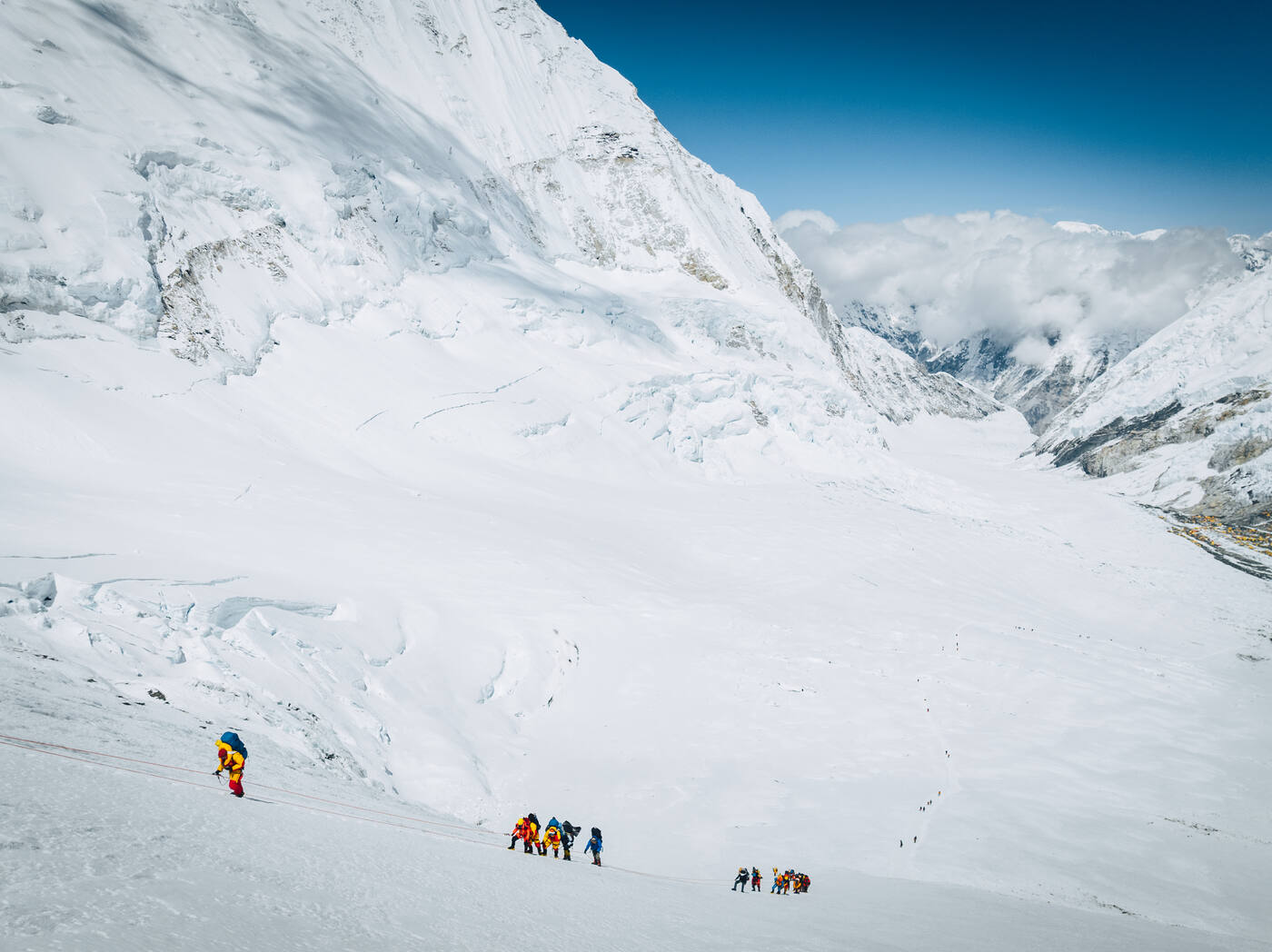 Aerial view of climbers on the Lhotse Face with the Western Cwm and clouds far below