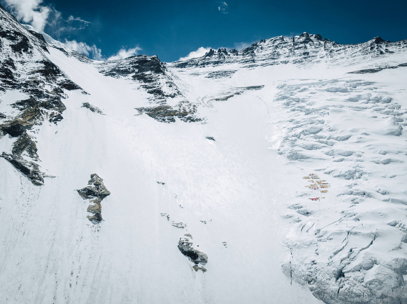 Aerial view of the Lhotse Face with a cluster of tents on its slope