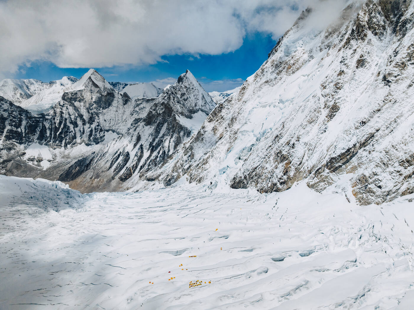 Aerial view of the upper Icefall and Western Cwm with tents below and sharp peaks under a dark sky