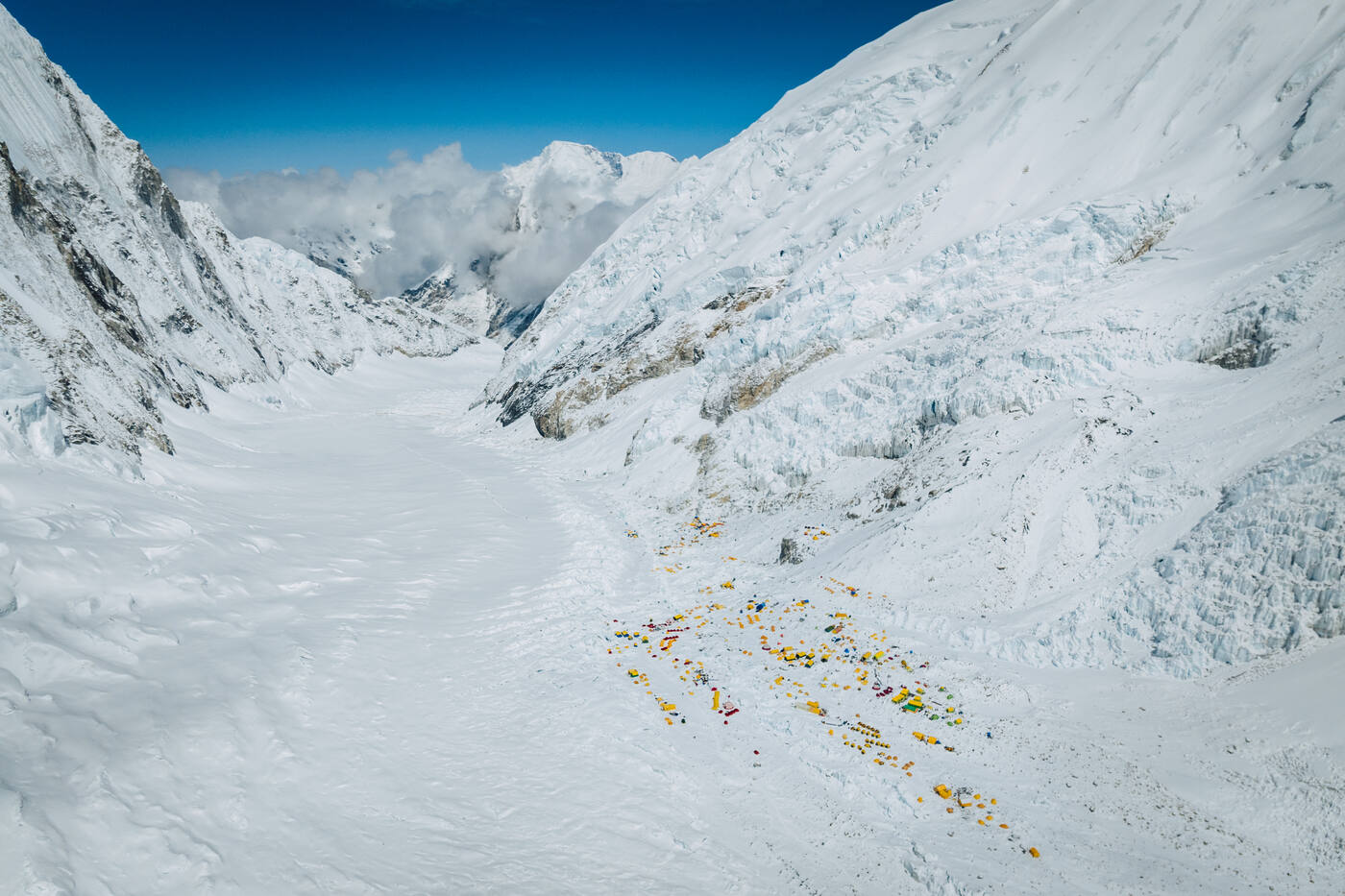 Aerial view of the Western Cwm with a cluster of tents at the edge of the glacier