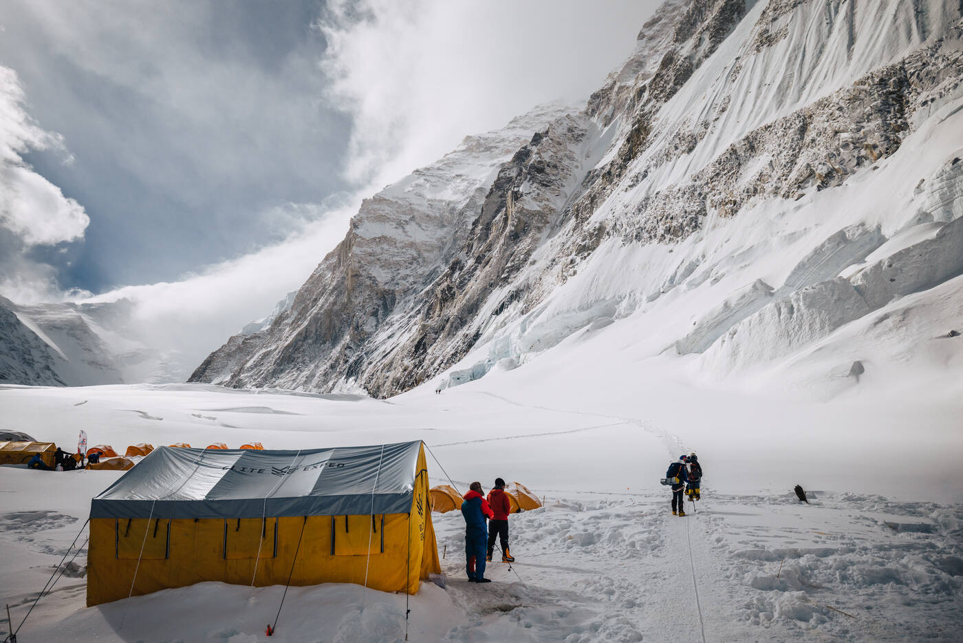 Camp 2 with tents and mess tent structure at the base of the Lhotse Face with climbers walking