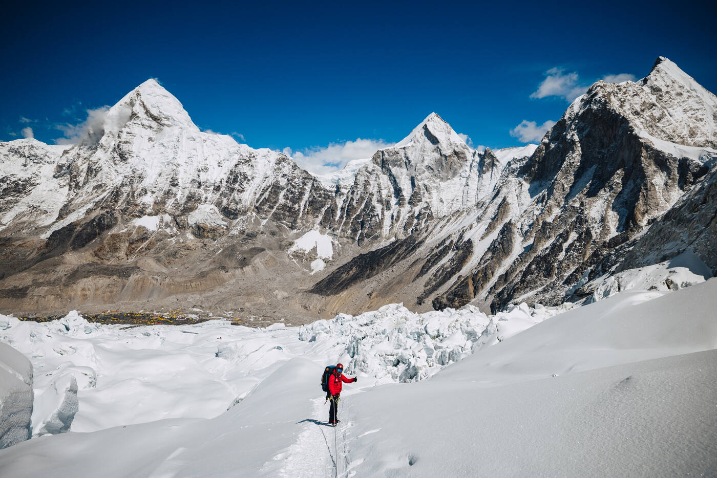 A climber in red in the Icefall with sharp snow peaks behind