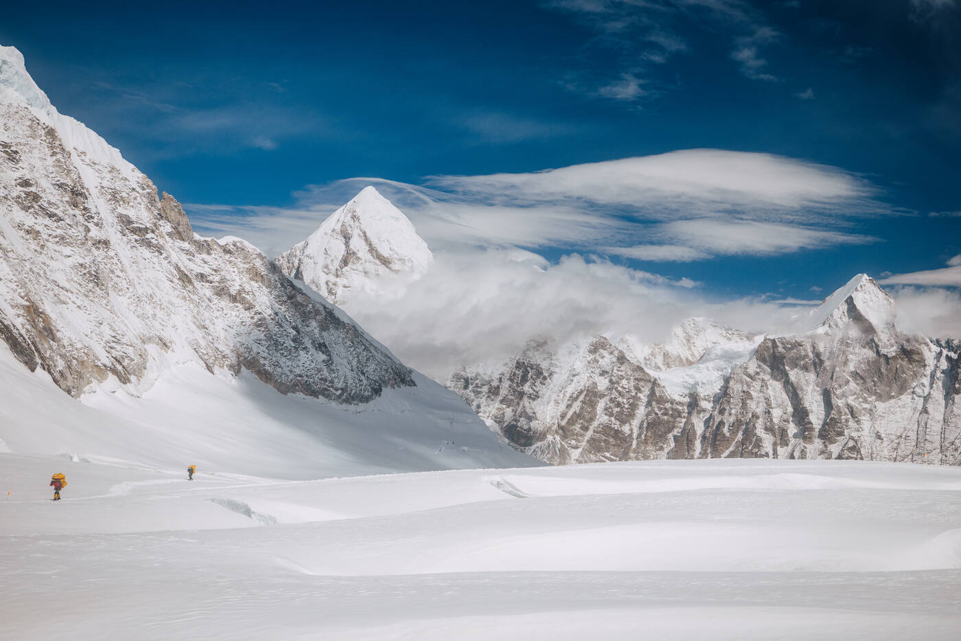 Panoramic view of the Western Cwm with tiny climbers walking across the massive glacial valley between Everest, Lhotse, and Nuptse