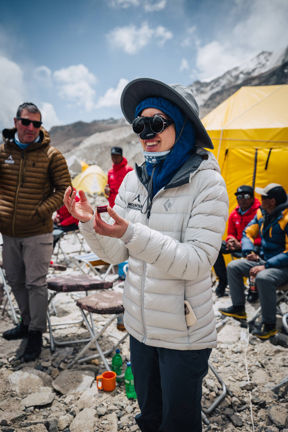 Grace smiling in a white down jacket holding an offering during the Puja ceremony