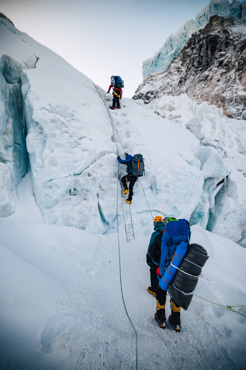 Climbers ascending steep ice and ladders in the Khumbu Icefall
