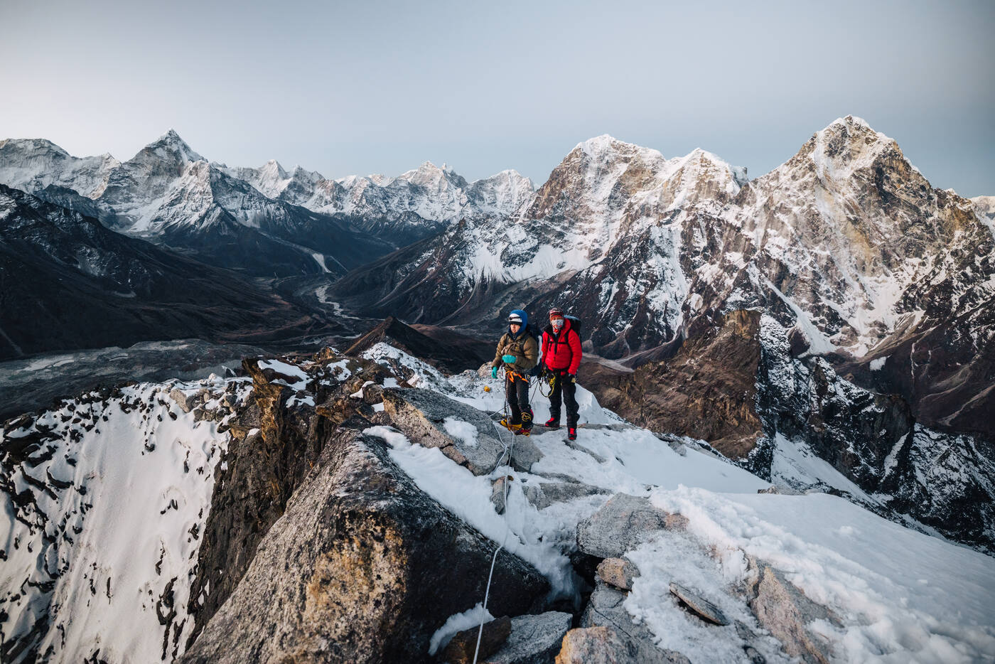 Two climbers on the rocky ridge of Lobuche East with snow peaks and the valley behind