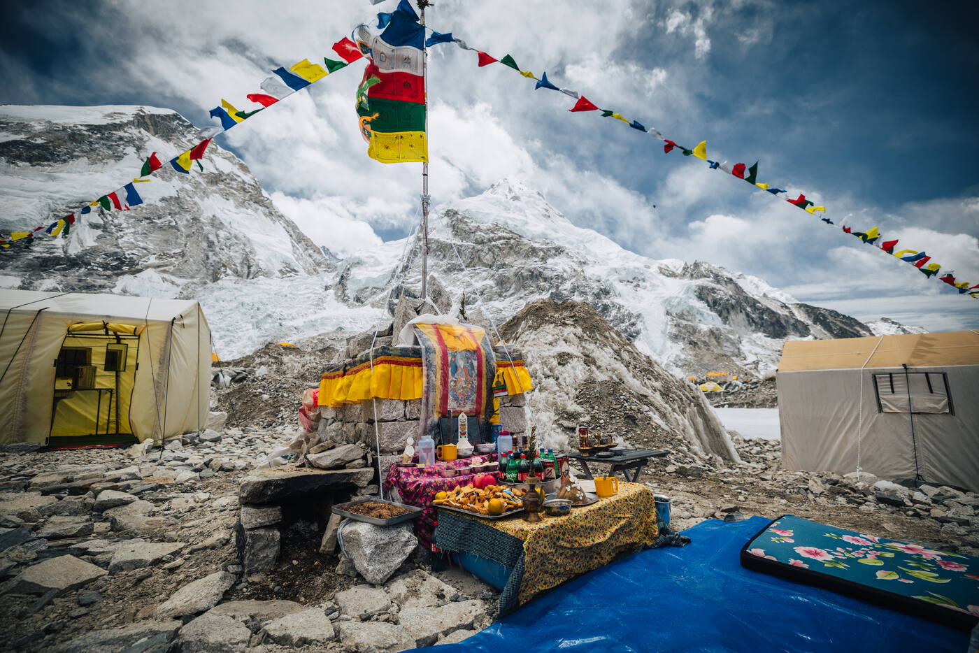 Stone altar chorten decorated with colorful prayer flags and offerings at Everest Base Camp during Puja ceremony