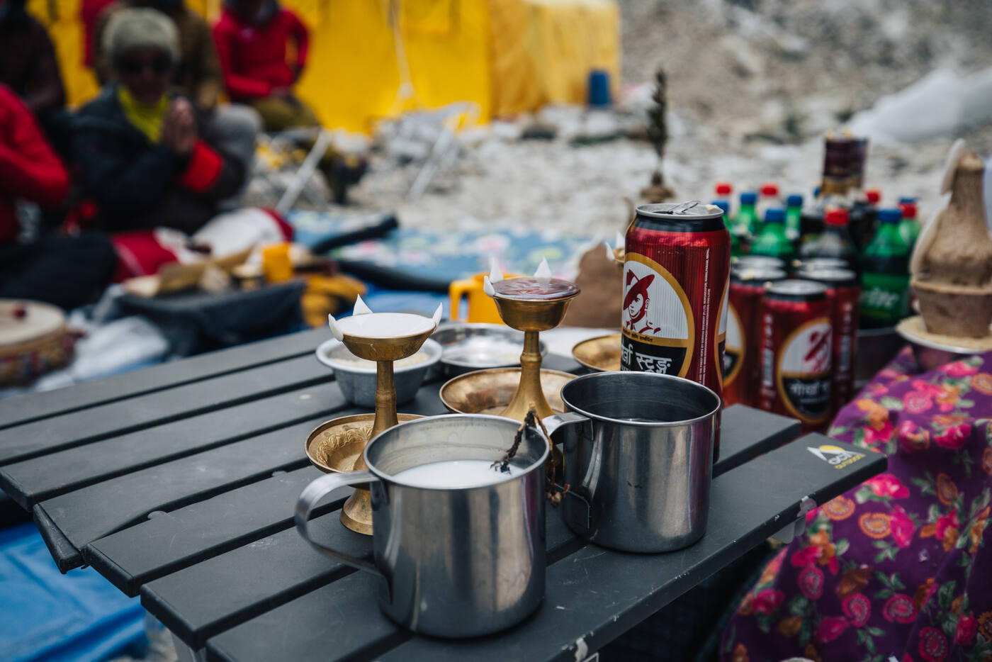 Puja offering table with butter lamps, metal cups, and ceremonial drinks at Everest Base Camp