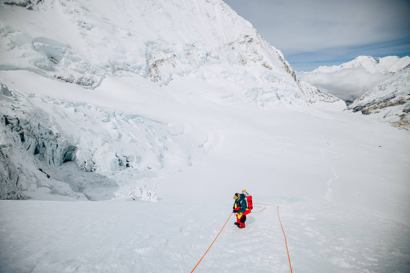 A single roped climber walking across the snow of the Western Cwm