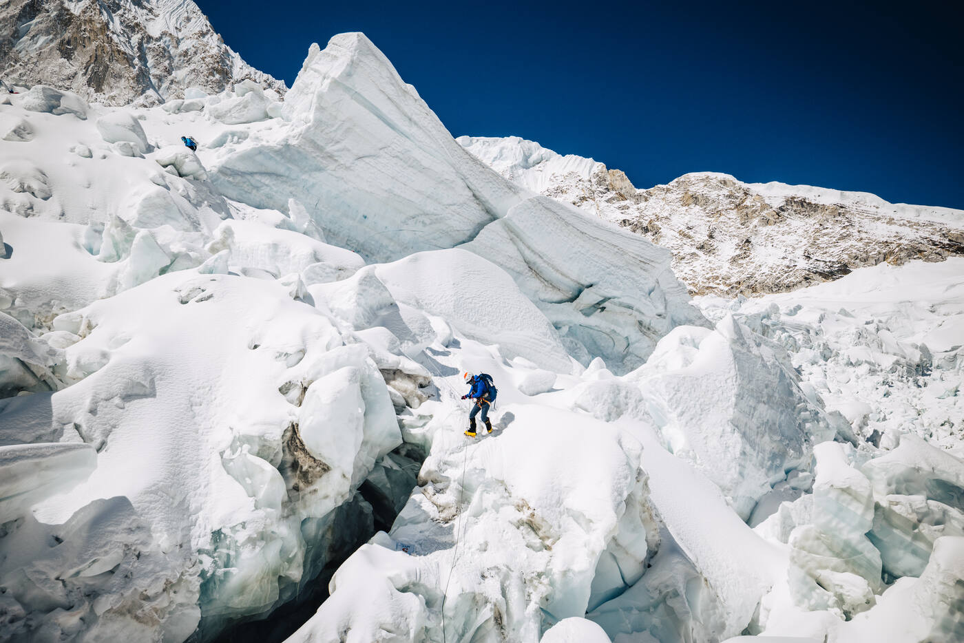 Single climber navigating among large ice seracs and blocks in the Khumbu Icefall
