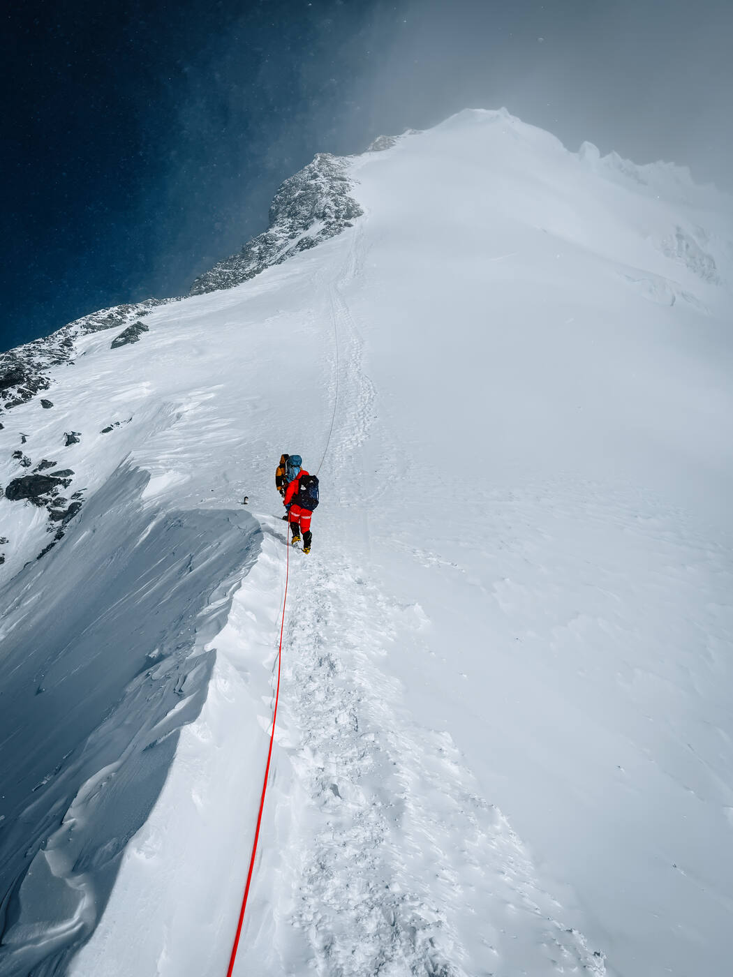 Climbers ascending the steep snow slope above the Balcony at 8,400 meters
