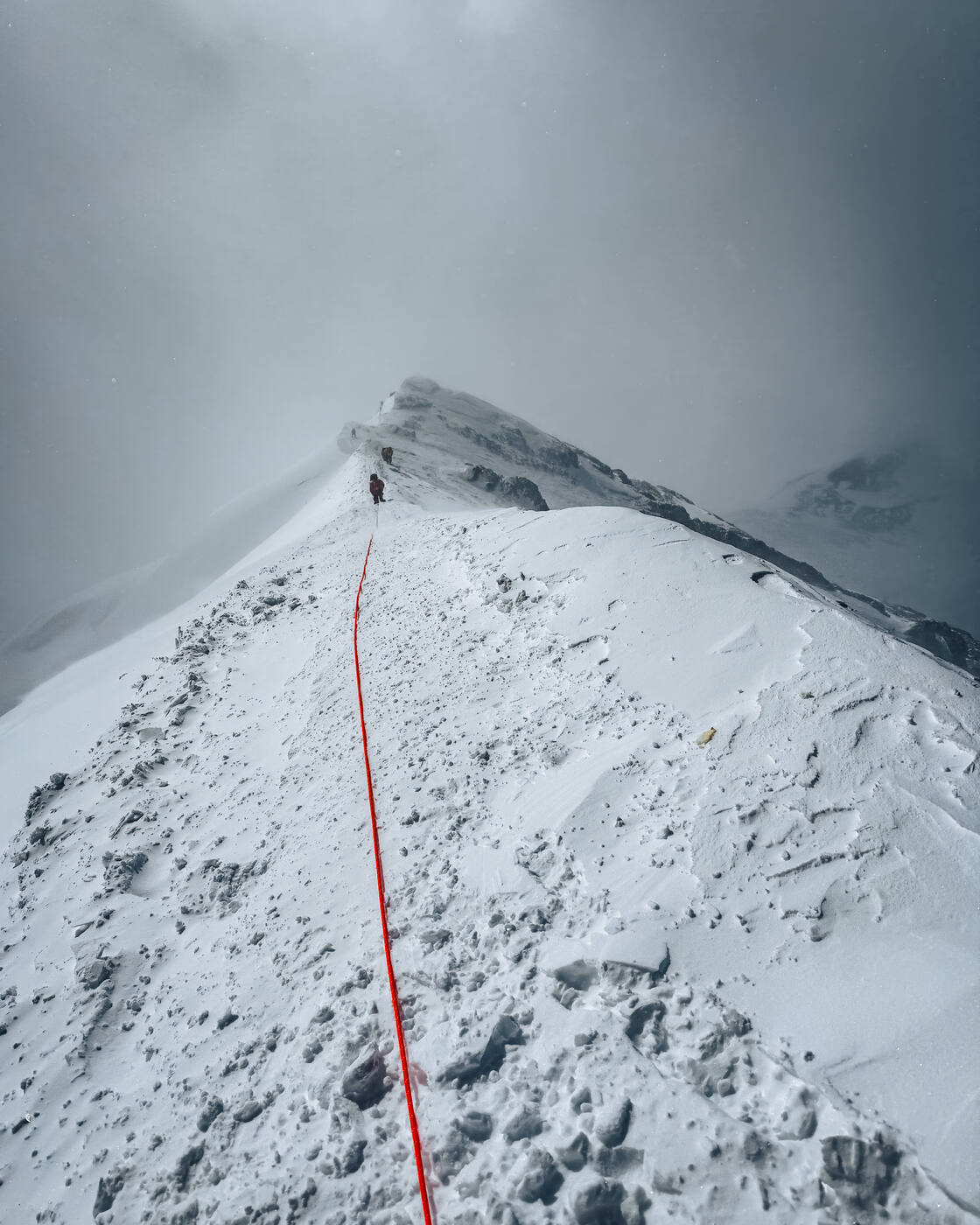 Approaching the South Summit with steep snow and exposed ridge
