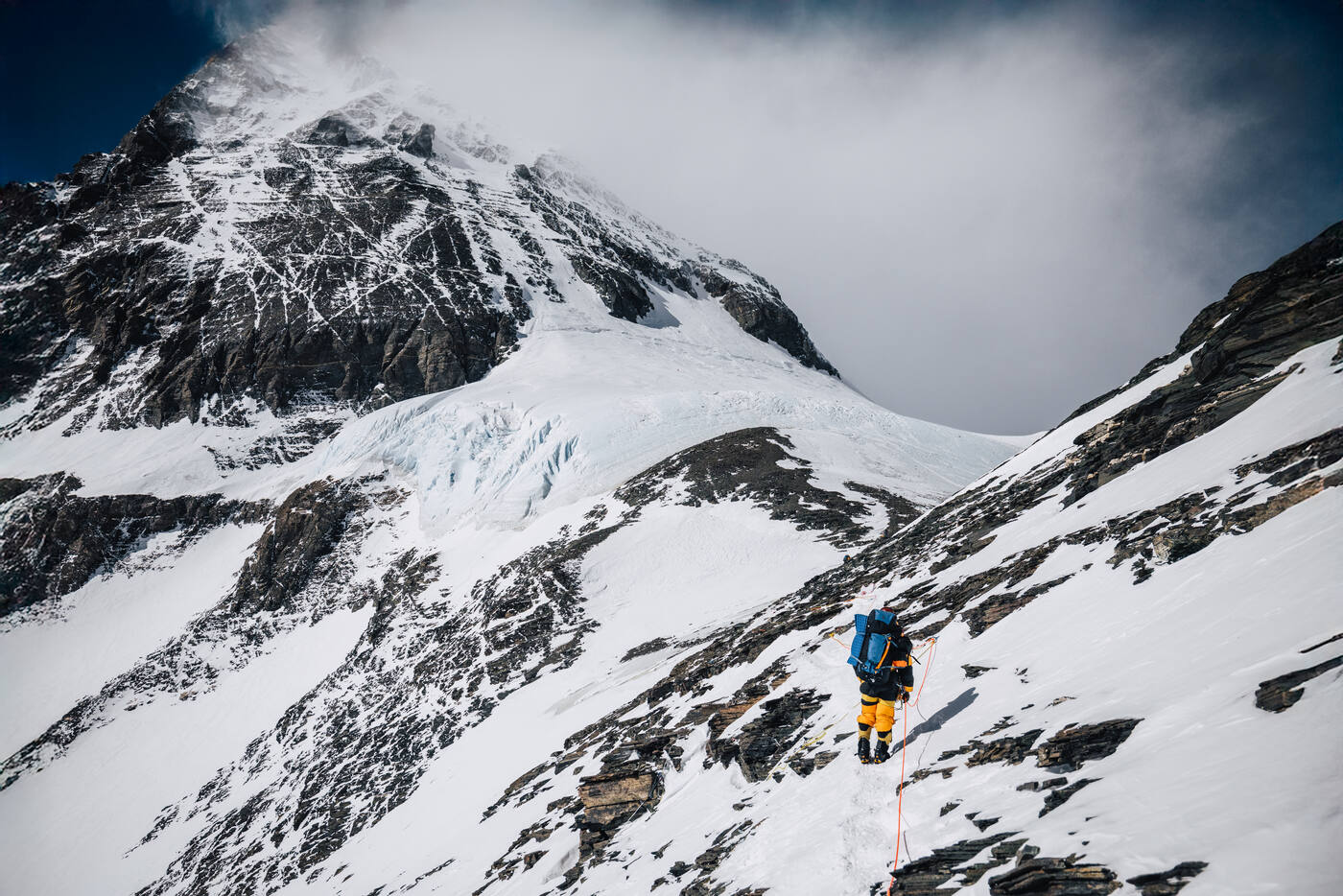 Climber ascending above Camp 3 on the Lhotse Face with the summit of Everest visible above