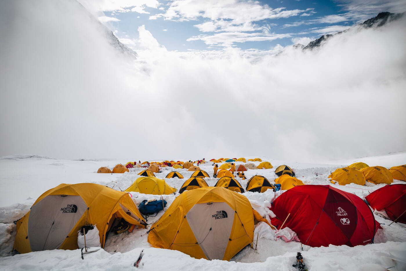 Tents at Camp 2 with cloud swirling over the mountain walls above