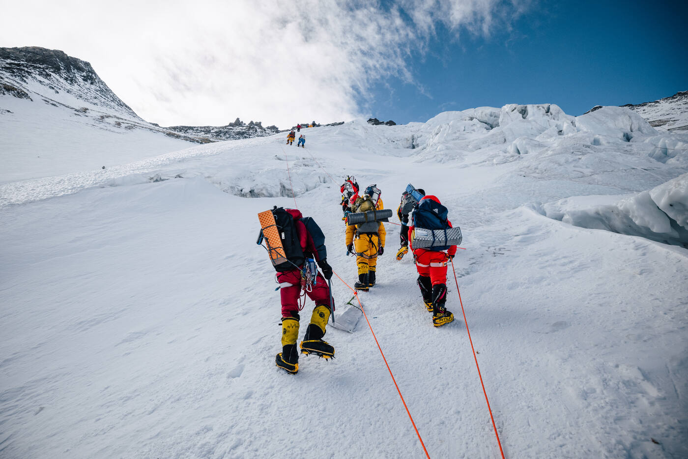 Climber ascending the steep Lhotse Face with fixed ropes in bright sunshine