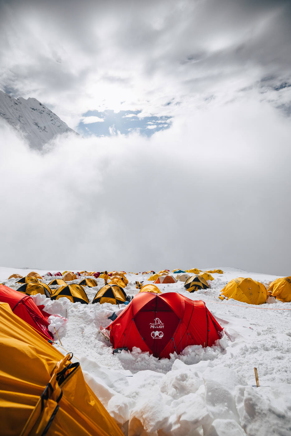 Red and yellow tents at Camp 2 with dramatic clouds and the Lhotse Face above