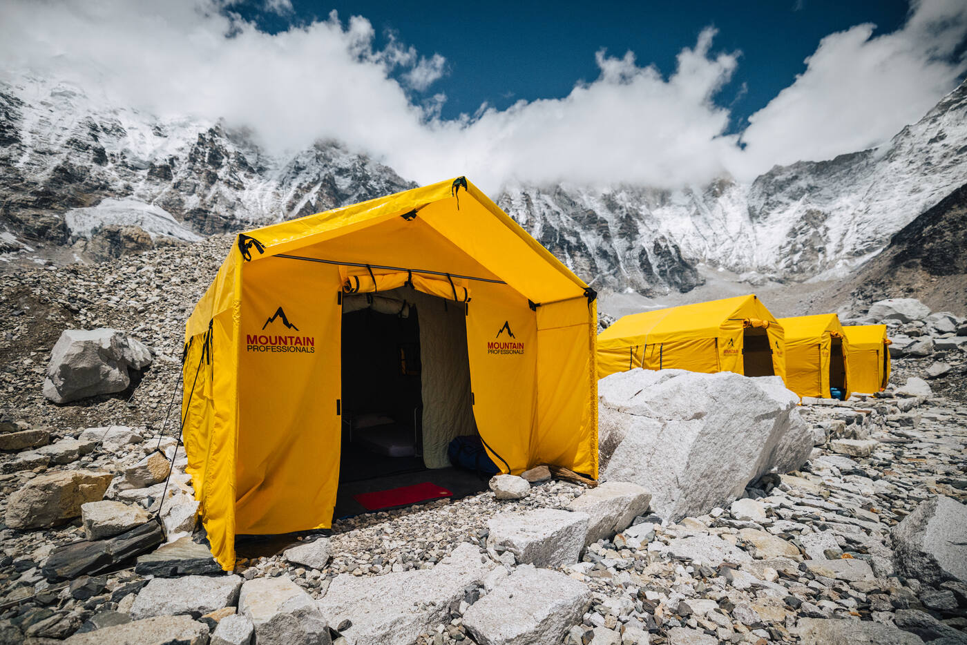 Yellow Mountain Professionals tents at Everest Base Camp with Khumbu Icefall and peaks behind