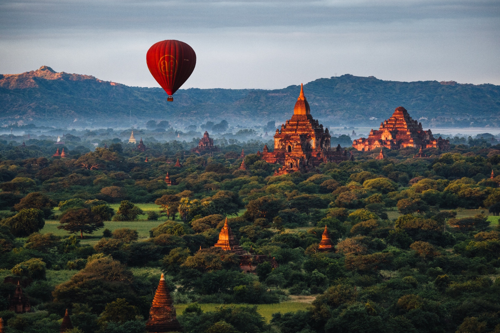 Hot air balloon floating over ancient Bagan temples at sunrise in Myanmar