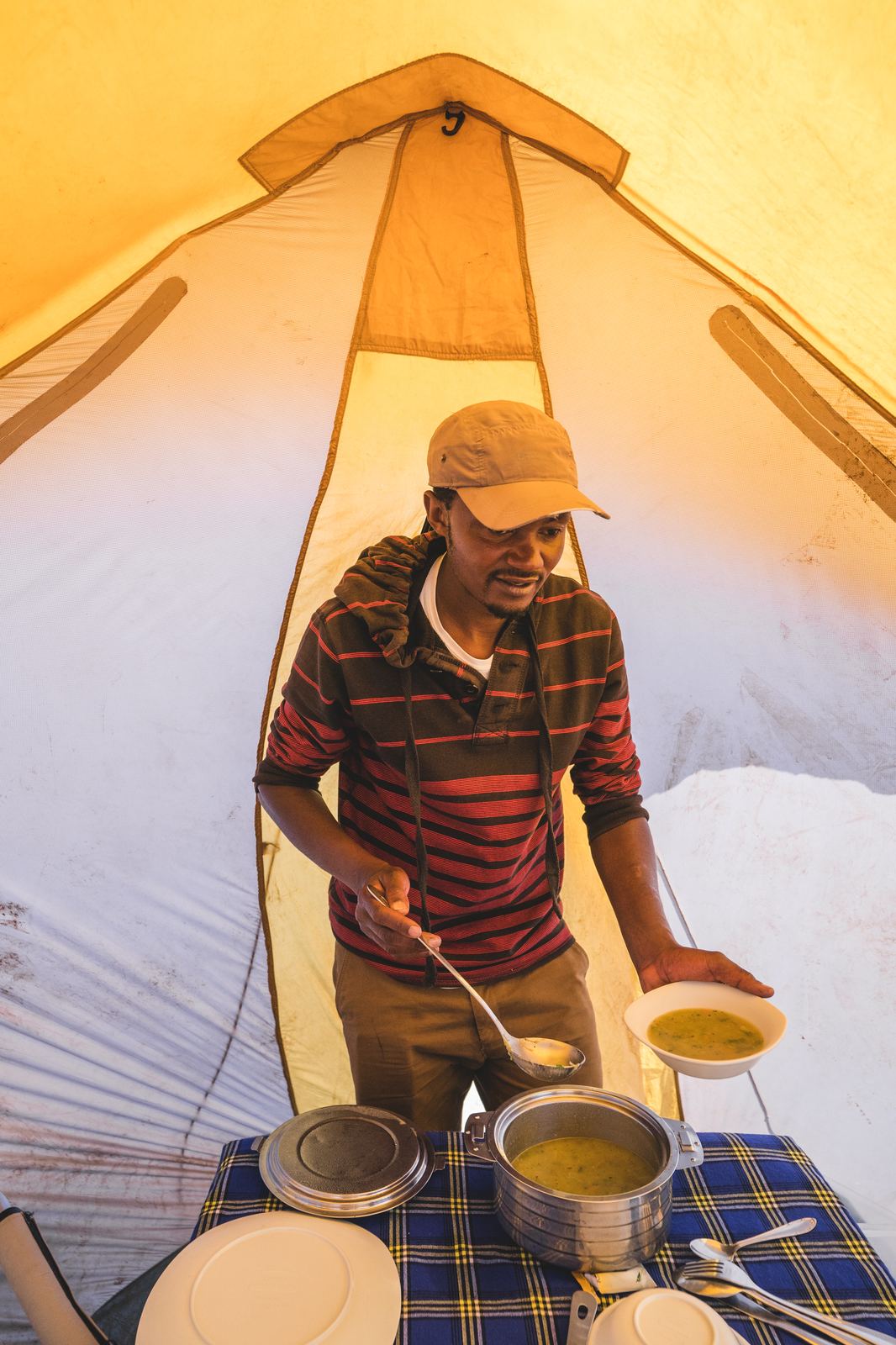 Camp cook serving hot soup inside the tent at Barafu Camp