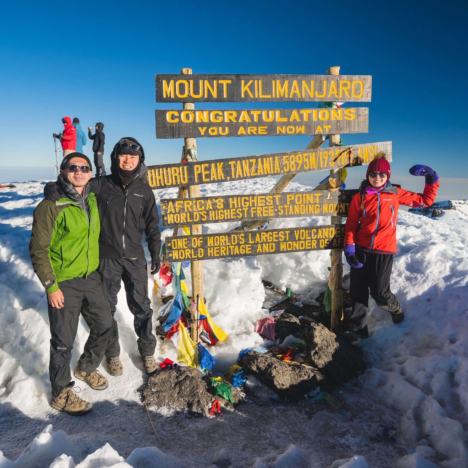 The climbing team celebrating at the Uhuru Peak summit sign