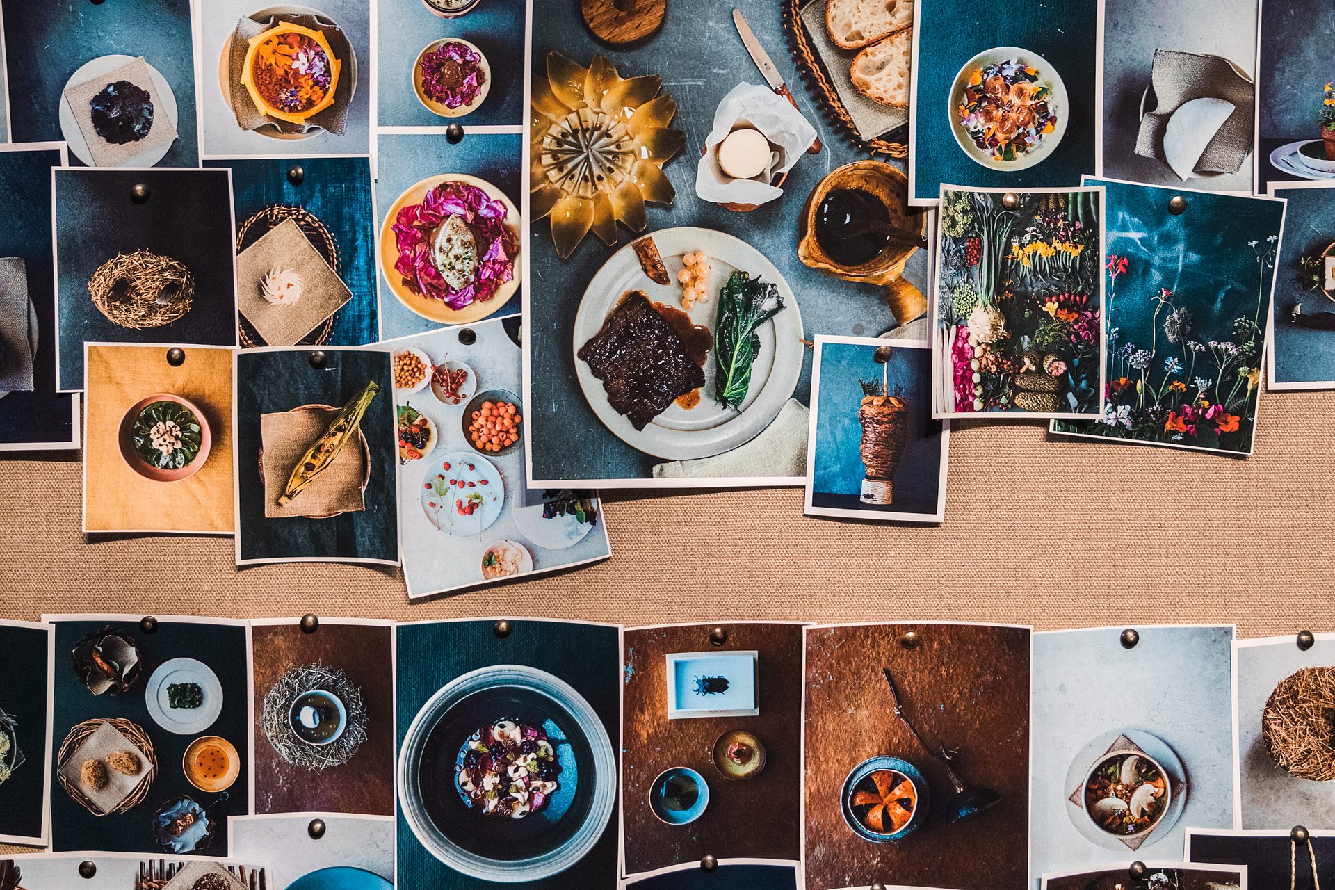 A wall of pinned photographs of dishes from restaurants around the world