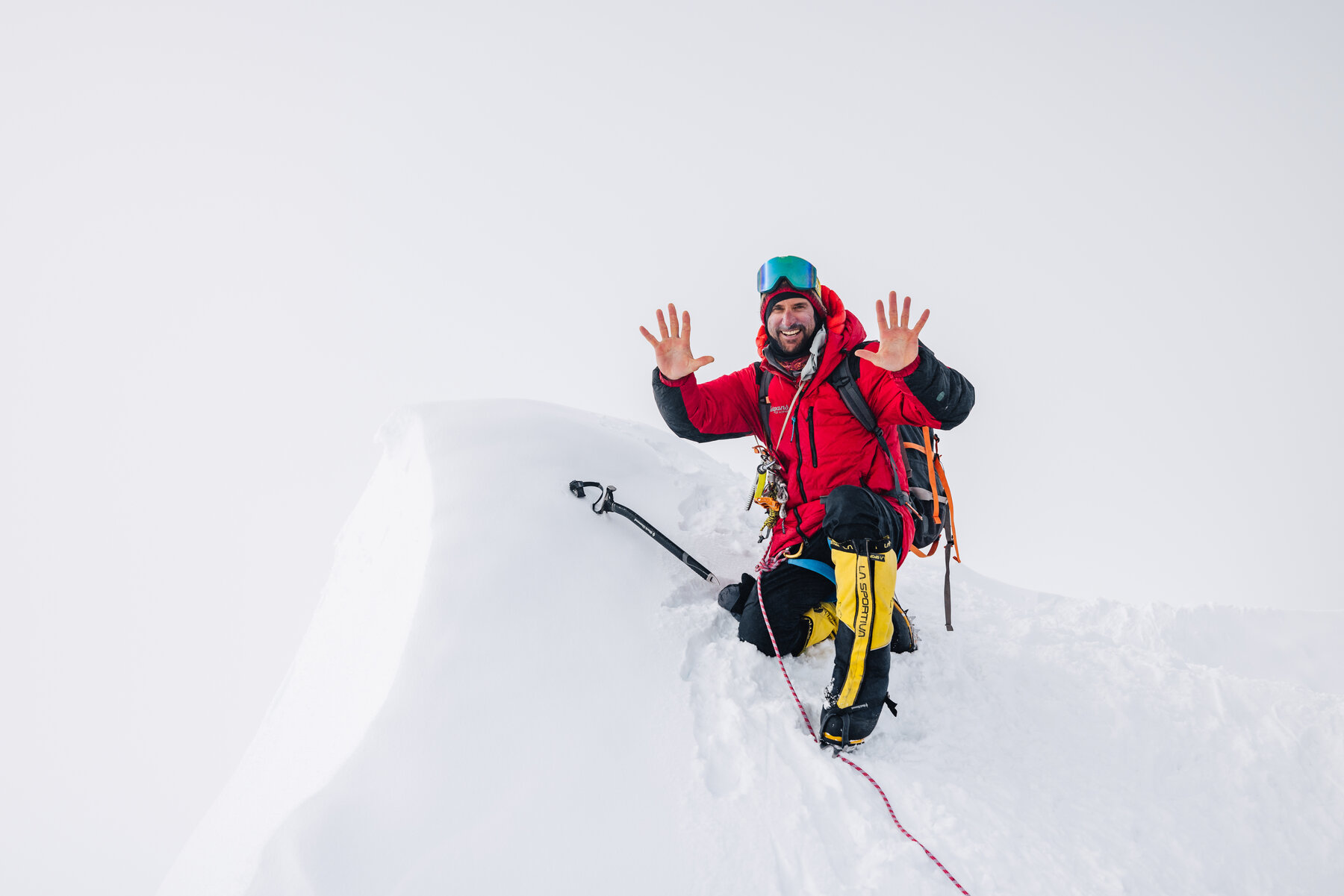 Climber with arms raised in personal victory at the summit