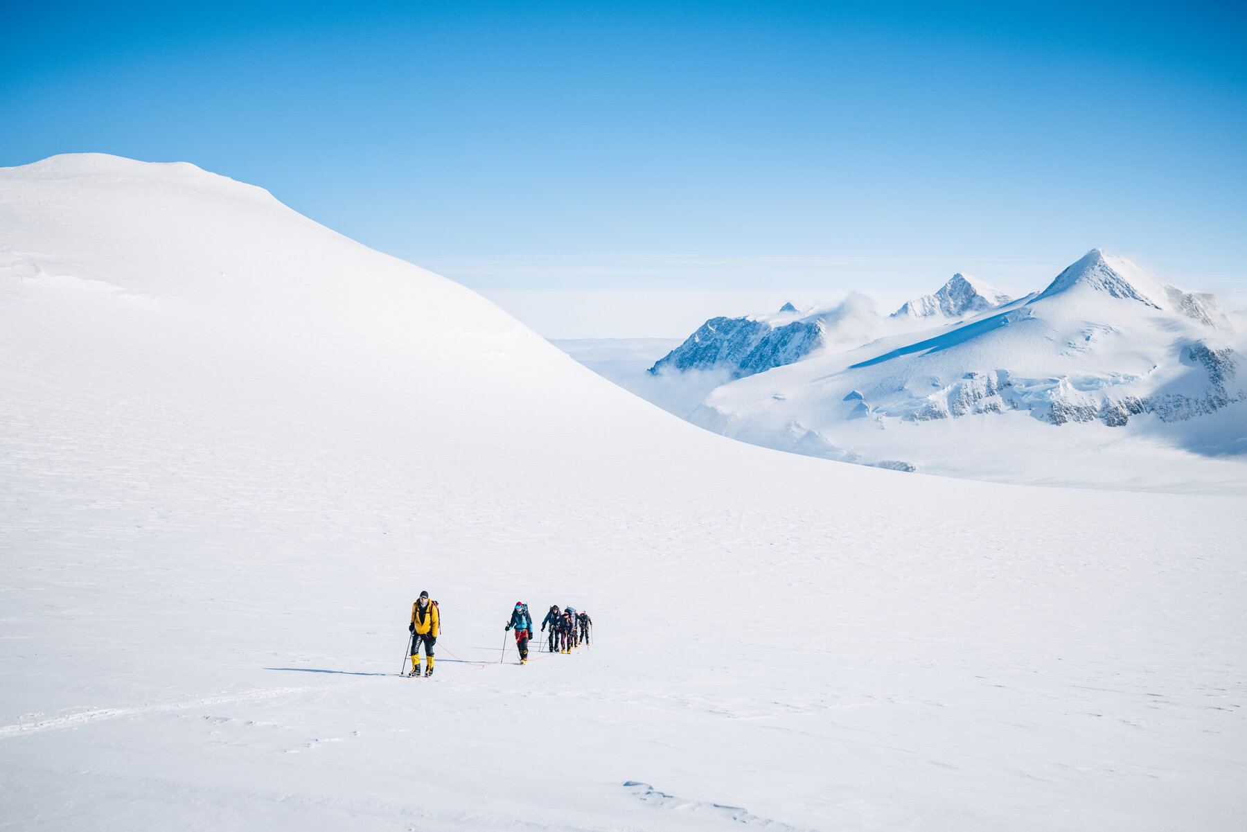 Climbing team approaching the summit of Vinson on a clear day with mountains visible