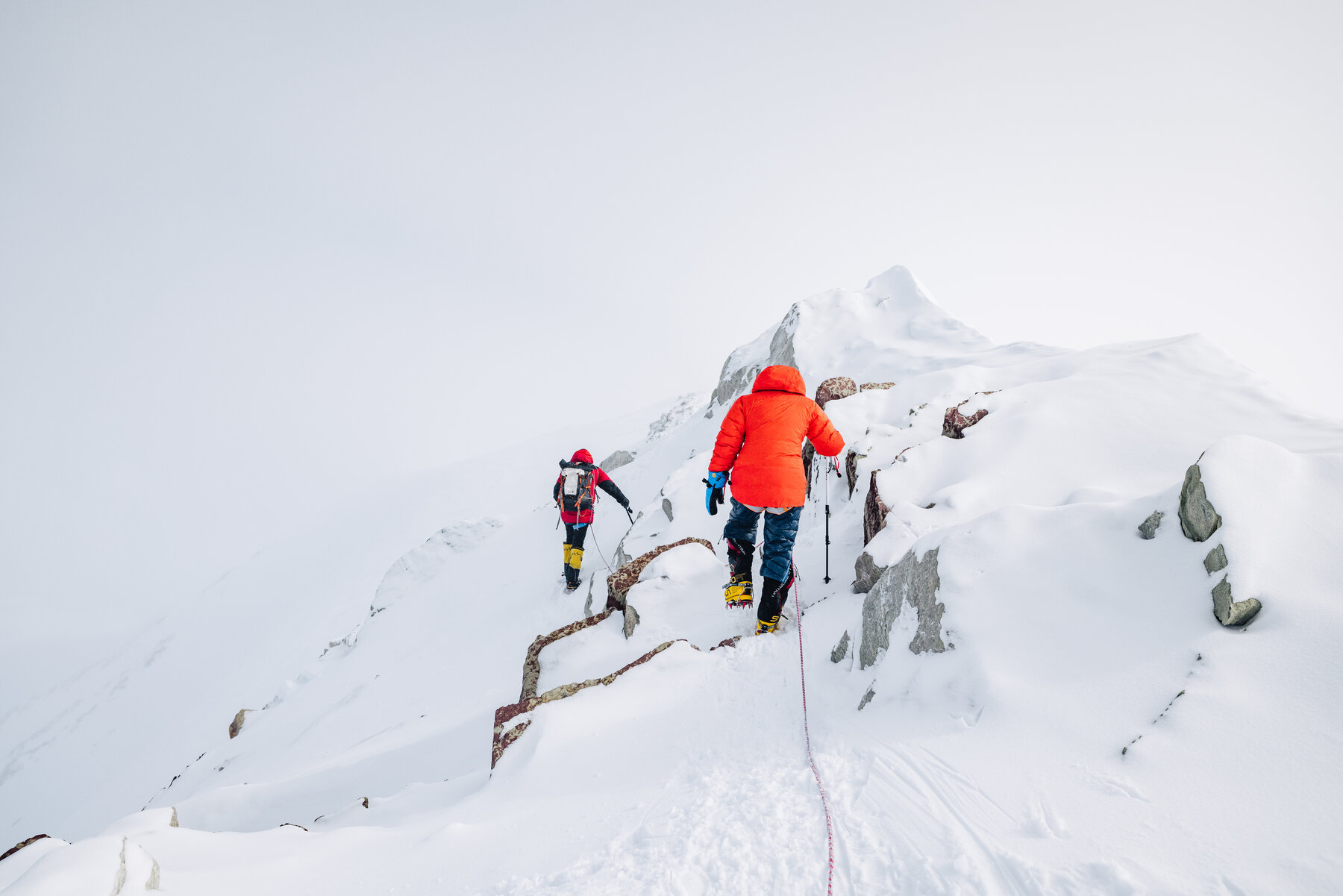 Team on the rocky summit ridge of Vinson with fog and snow