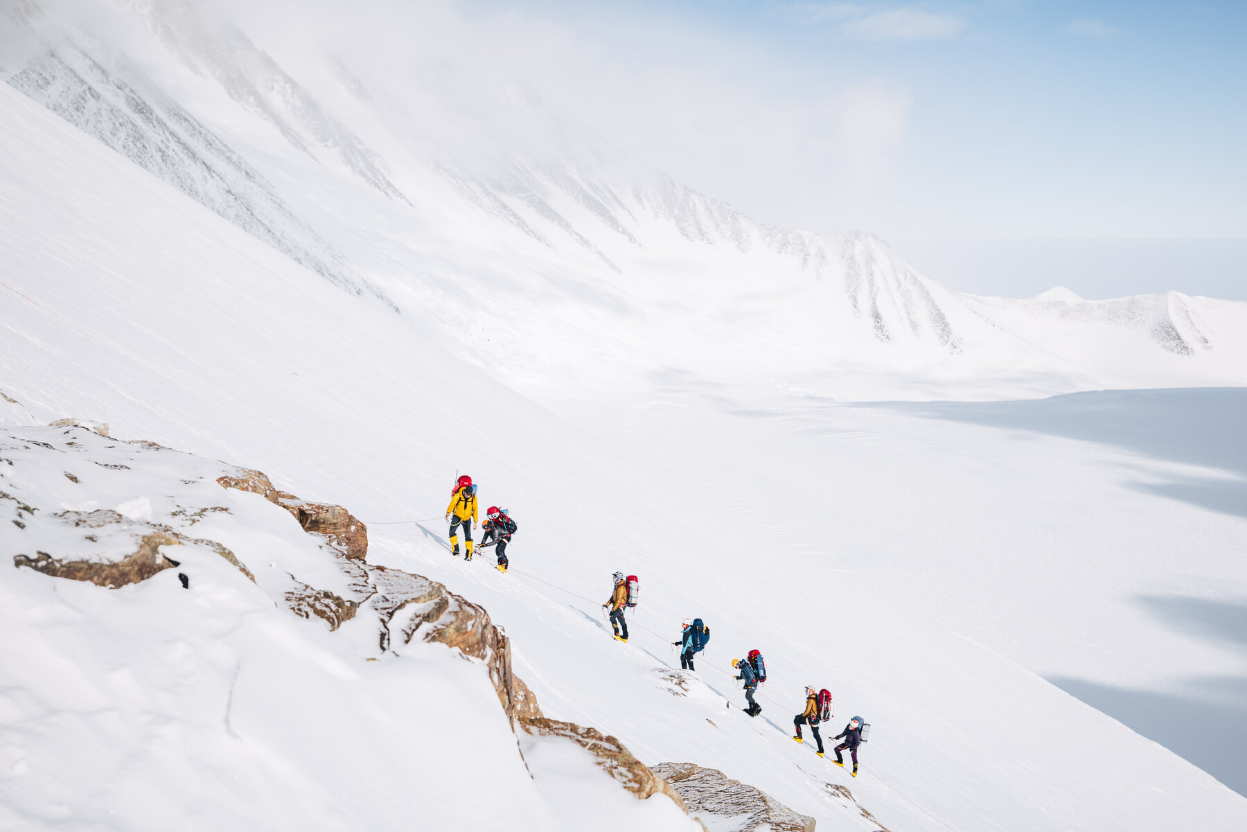 Line of climbers on the west face of Vinson with glacier visible below