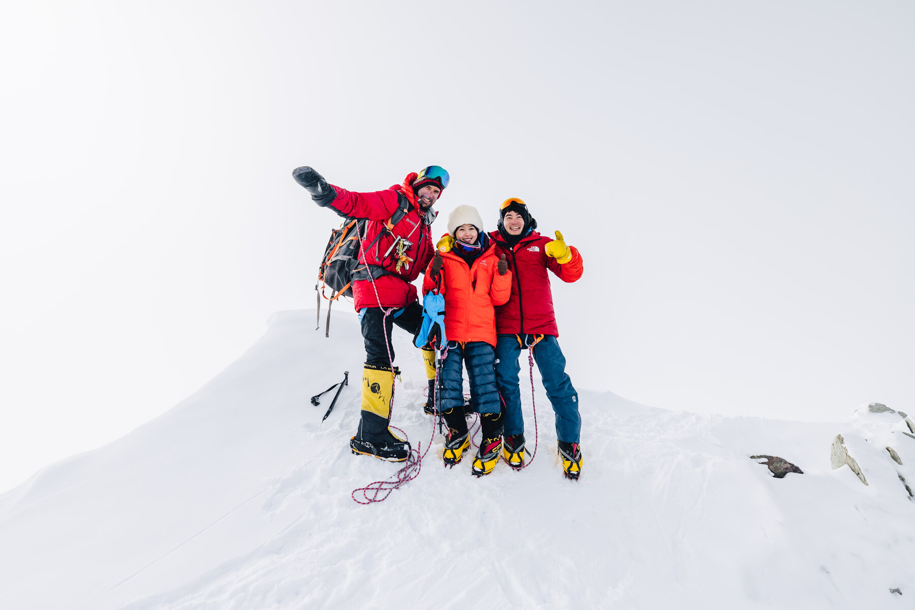 Team celebrating at the summit of Vinson Massif with fists raised