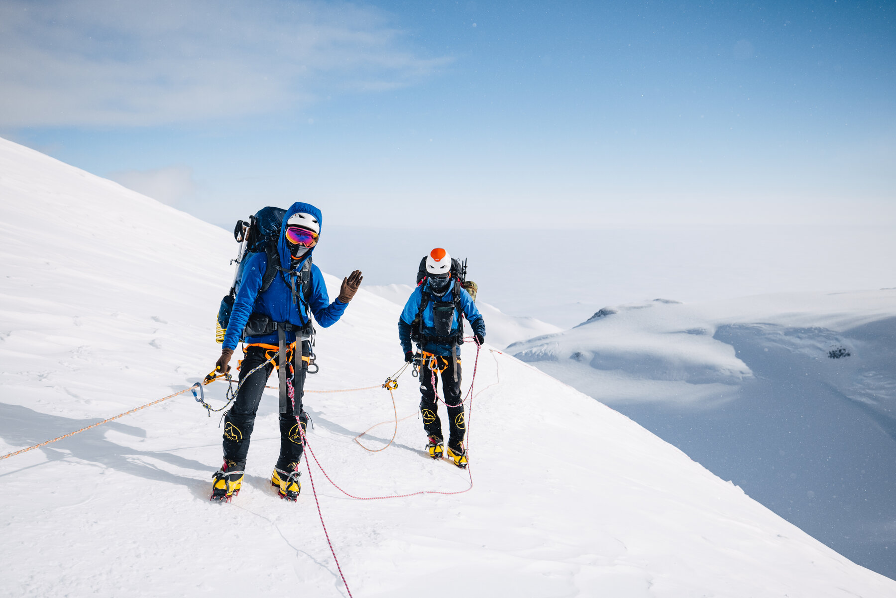 Two climbers roped together ascending a steep snowy slope on Vinson
